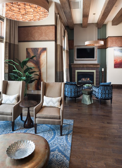 a living room with chairs and a table and a fireplace