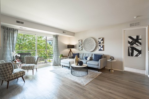 a living room with a couch and chairs and a door to a balcony